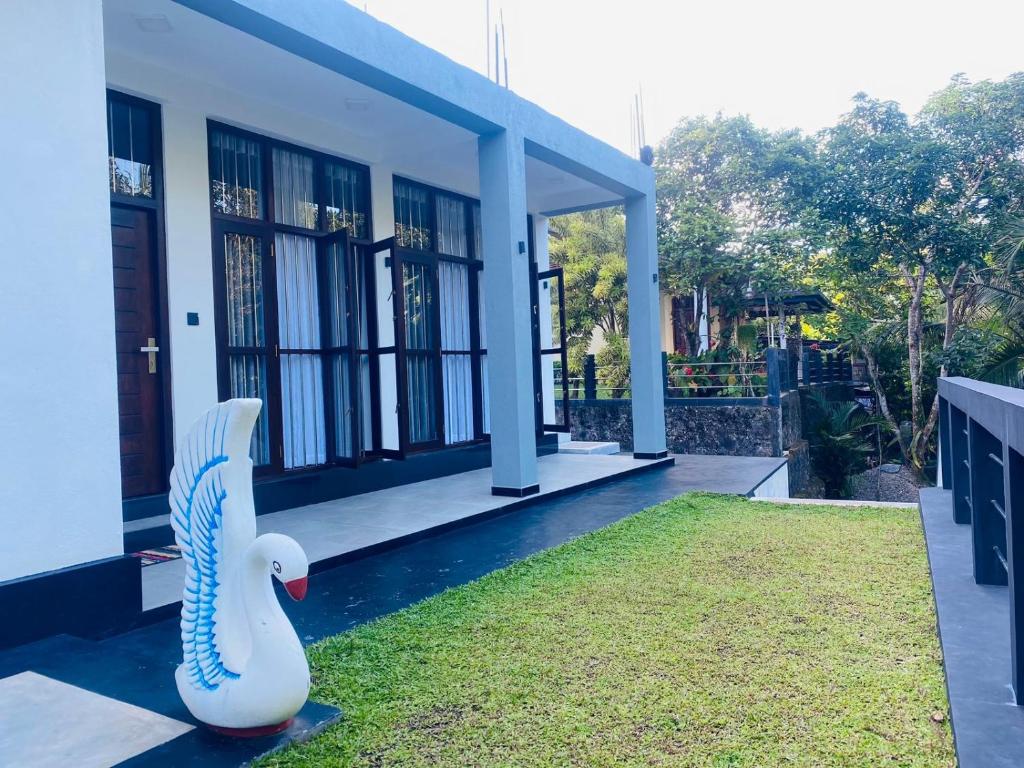 a house with a swan statue in front of it at Thanu Villa in Unawatuna