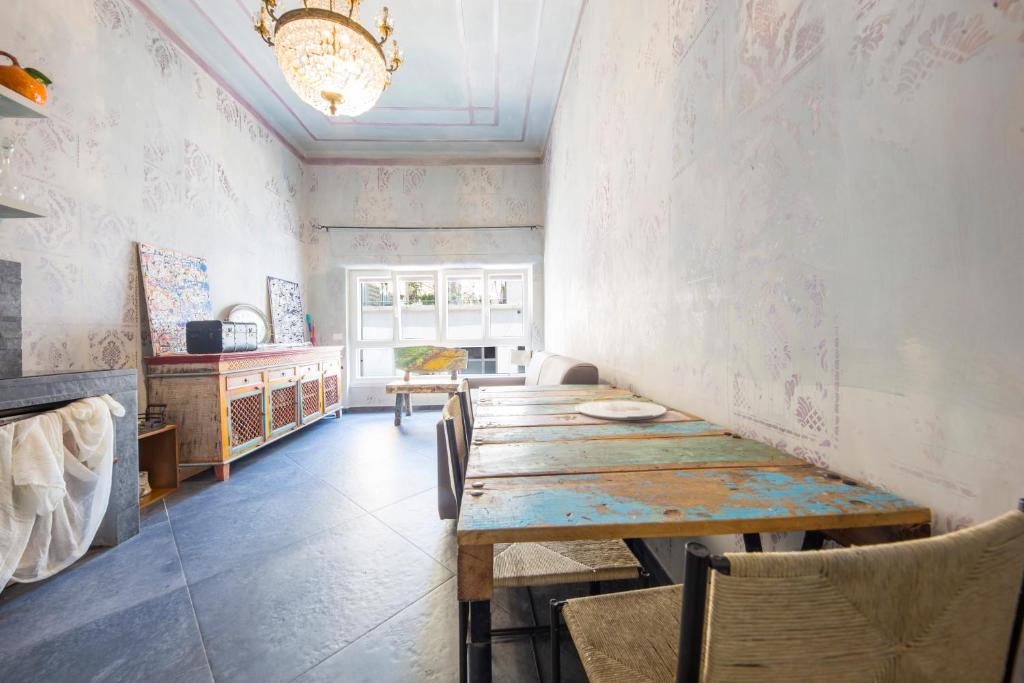 uma sala de jantar com mesa e cadeiras de madeira em Art Gallery Apartment em Génova