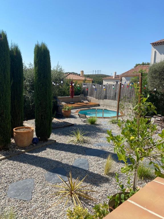 un jardin avec une piscine, des arbres et une clôture dans l'établissement Studio entre Aix en Provence et Marseille et parking, à Septèmes-les-Vallons