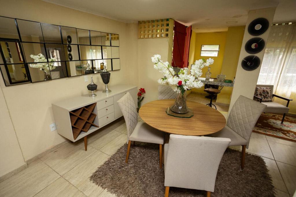 サンタ・テレサにあるOtima casa com Wi-Fi em Santa Teresa ESのダイニングルームテーブル(椅子付)、花瓶