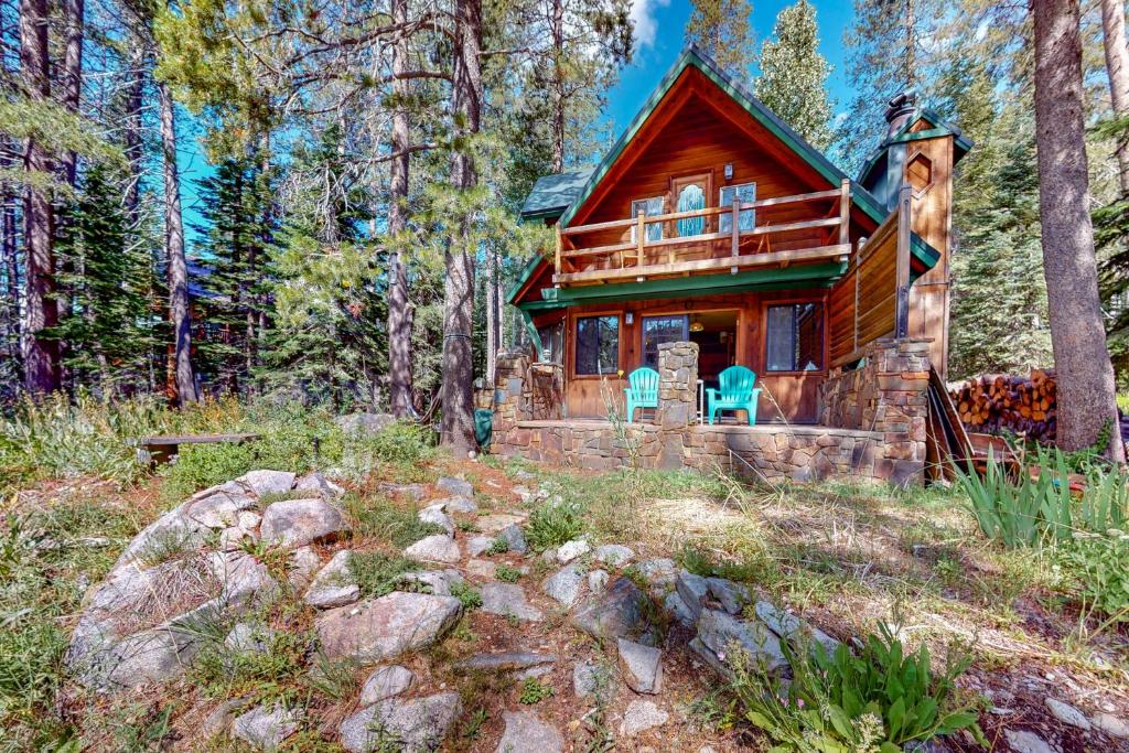 a log cabin in the woods with two blue chairs at Sierra Secret in Soda Springs