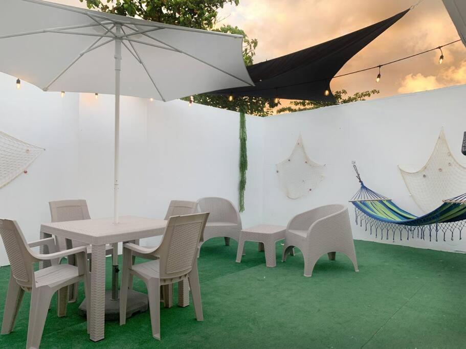 a white table and chairs with an umbrella at Villa del Sol in Luquillo