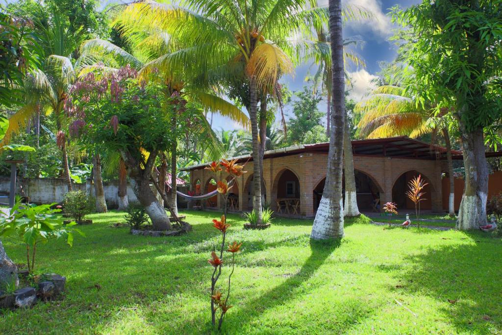 une maison dans une cour avec des palmiers dans l'établissement VILLA LAS FLORES, à La Libertad