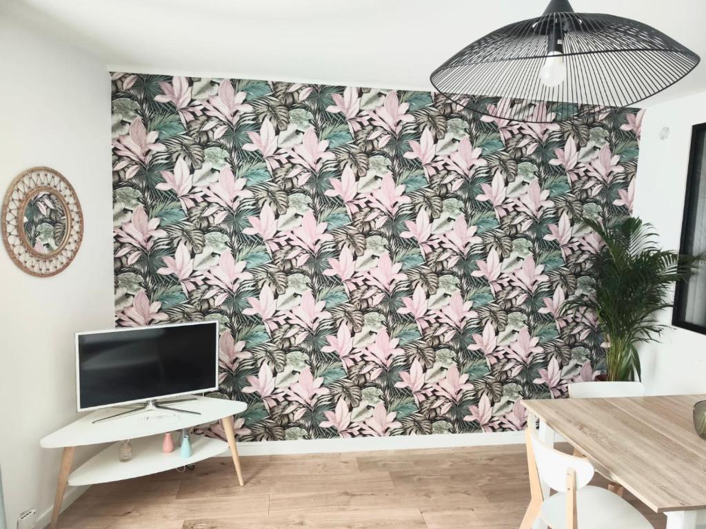 Zimmer mit einer Wand mit rosafarbener Blumentapete in der Unterkunft Stylish flat in a quiet area close to amenities in Melun