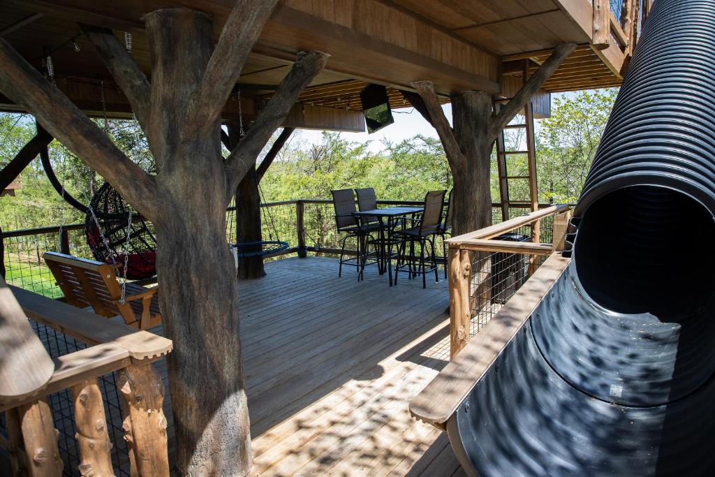 a large wooden deck with a table and chairs on it at "Air Fort One" Aviation-Themed Luxury Treehouse Near Dollywood & Pigeon Forge in Sevierville