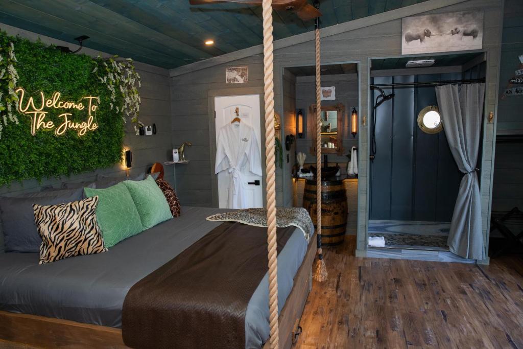 a bedroom with a hanging bed and a room with a mirror at "Tarzan & Jane" Jungle-Themed Double Luxury Family Treehouse for 12 Near Dollywood & Pigeon Forge in Sevierville