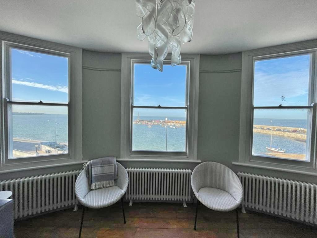 uma sala de estar com três cadeiras e três janelas em Stunning 2 bedroom Sea View - Margate Old Town em Margate