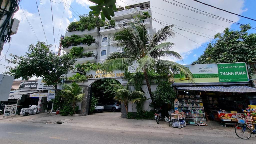 a white building with a palm tree in front of it at Ngoi Sao Phuong Nam Hotel in Ho Chi Minh City