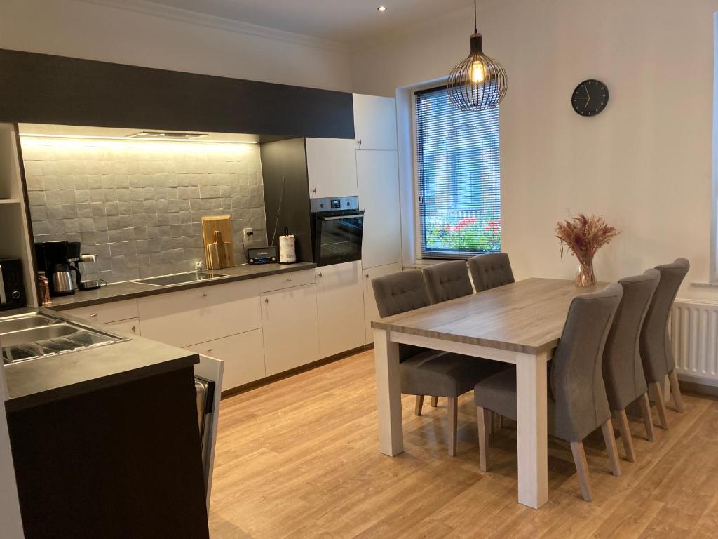 a kitchen and dining room with a table and chairs at EN PASSANT appartement in Diksmuide