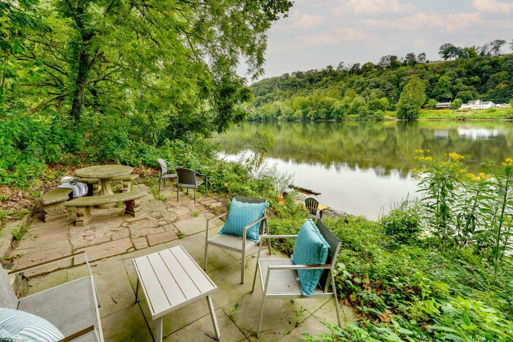 eine Terrasse mit Stühlen und einem Picknicktisch neben einem See in der Unterkunft Upper Black Eddy Home with Delaware River Access! in Upper Black Eddy