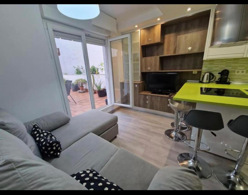 un soggiorno con divano e una cucina di Apartamento con terraza y parking a Gijón