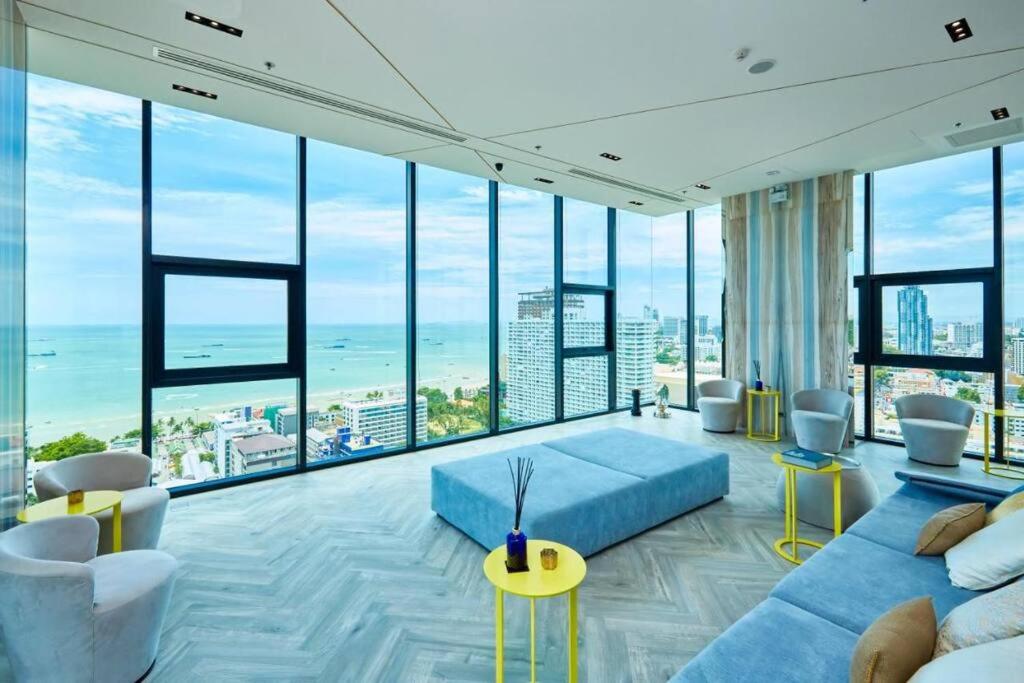 a living room with a blue couch and large windows at Sea View 2 Bed Room Condo @ Central Pattaya in Pattaya Central