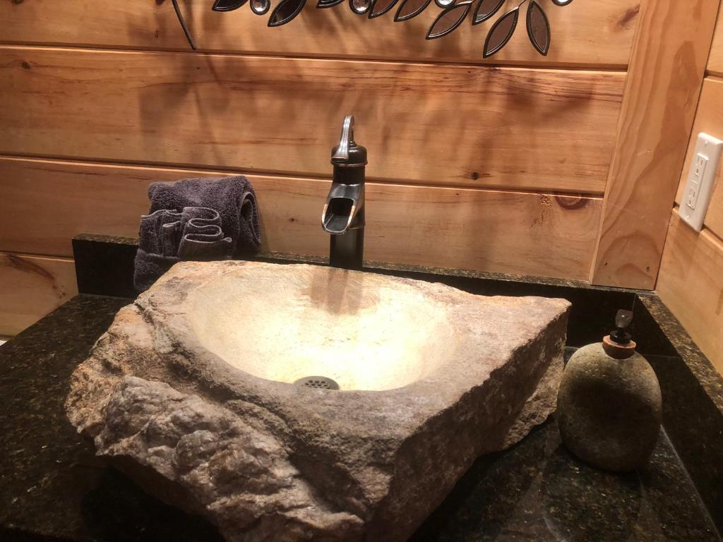 a bathroom with a stone sink with a faucet at Fontana @ Sky Ridge Yurts in Bryson City