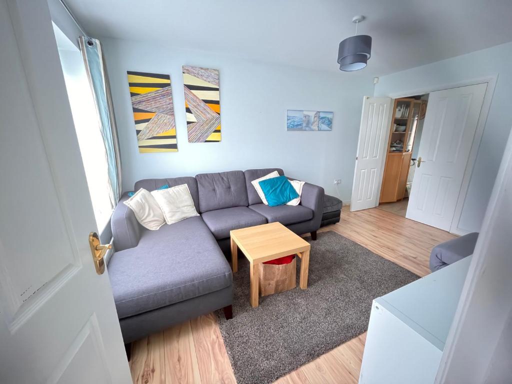 uma sala de estar com um sofá e uma mesa em 3BD Family Stay with a Garden Longbenton Newcastle em Newcastle upon Tyne