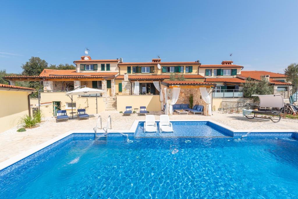 una villa con piscina di fronte a una casa di Kalista a Barbariga