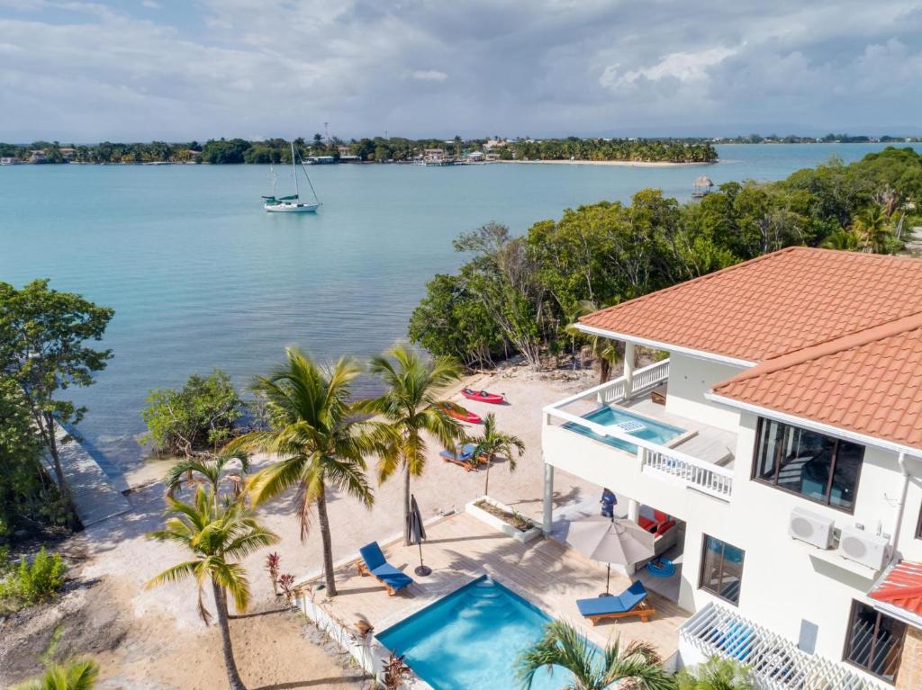 een luchtzicht op een huis en het strand met een boot in het water bij Island Time Gecko in Placencia Village