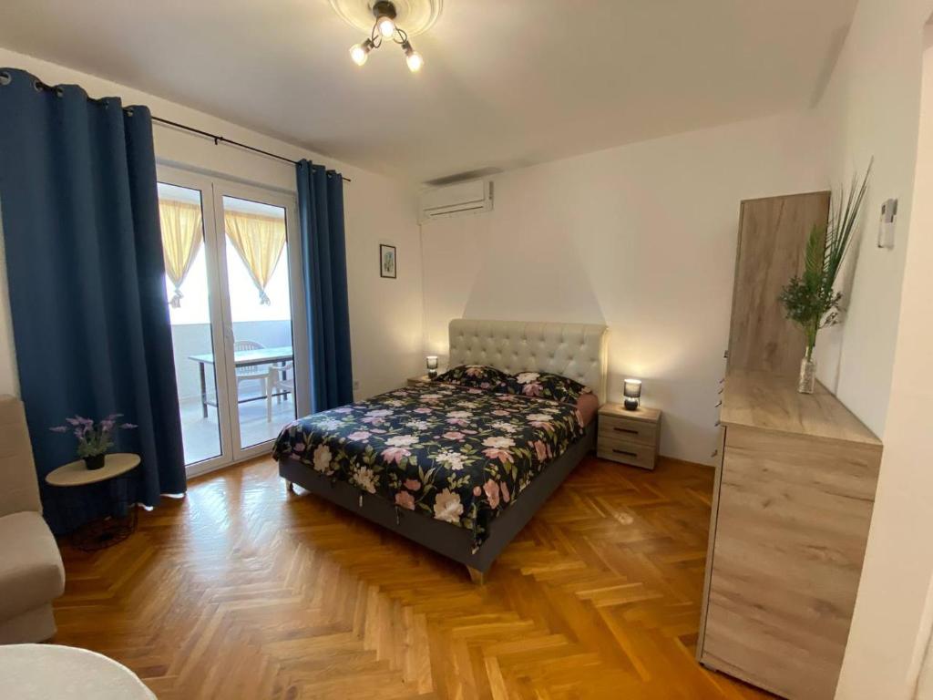 ein Schlafzimmer mit einem Bett und einem großen Fenster in der Unterkunft Alina's apartment in Becici