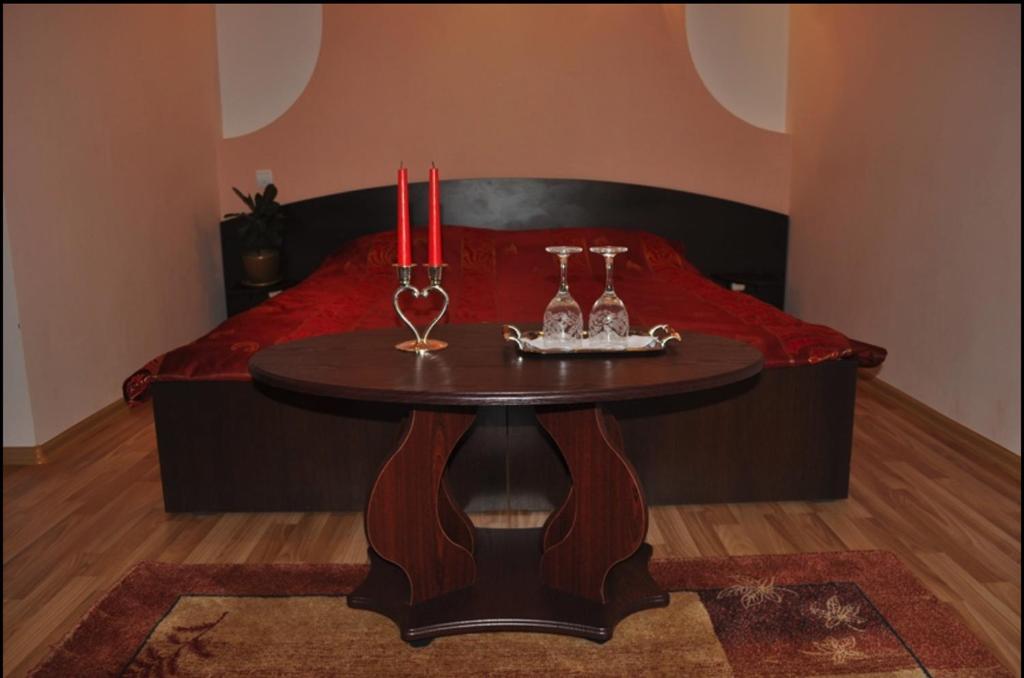 a room with a table with two candles and a bed at Hotel Ellegance 