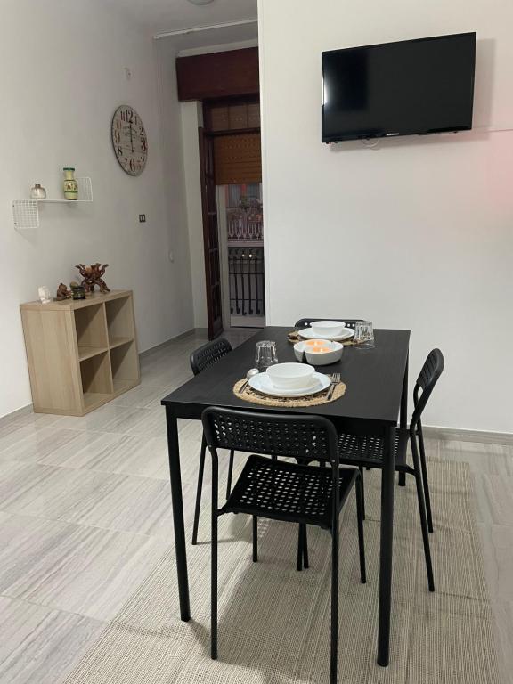 un tavolo nero con sedie e un piatto sopra di Casa Vacanza Rosati a Cerignola