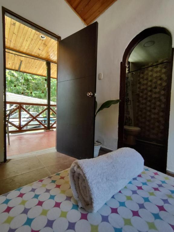 Un dormitorio con una cama con una toalla. en Bahareque Hostal, en Ibagué