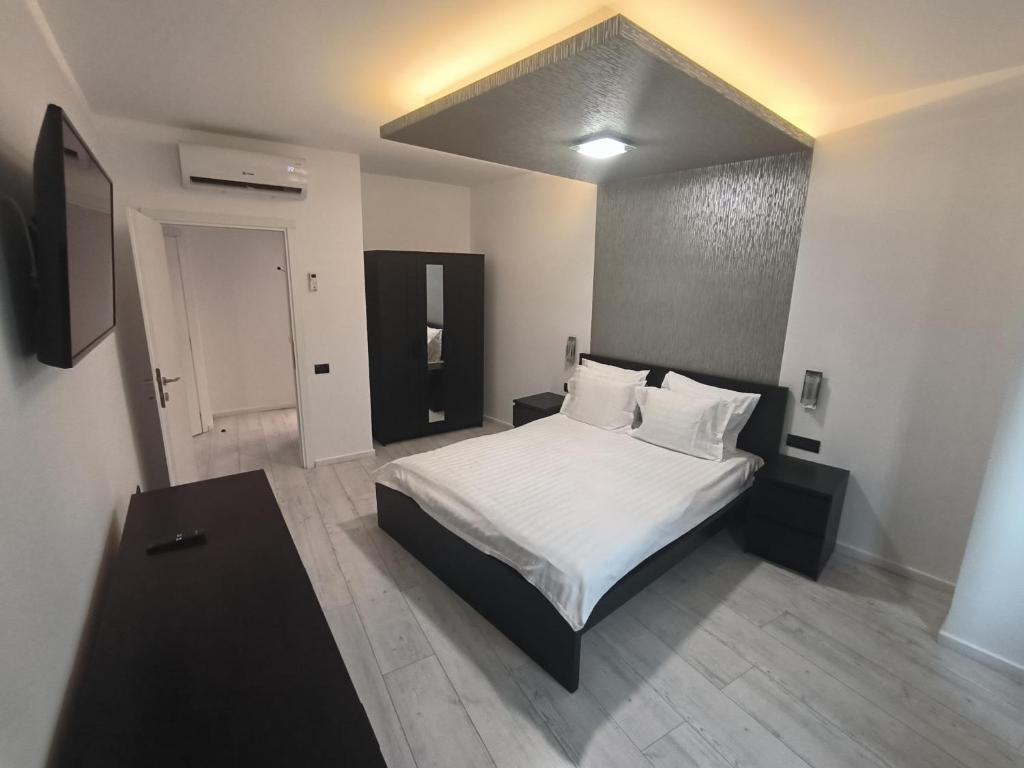 a bedroom with a bed with white sheets and pillows at Romana Residence in Bucharest