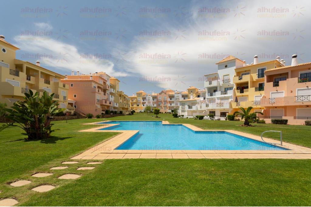 a swimming pool in front of some apartment buildings at Jardins de Santa Eulália By Albufeira Rental in Albufeira
