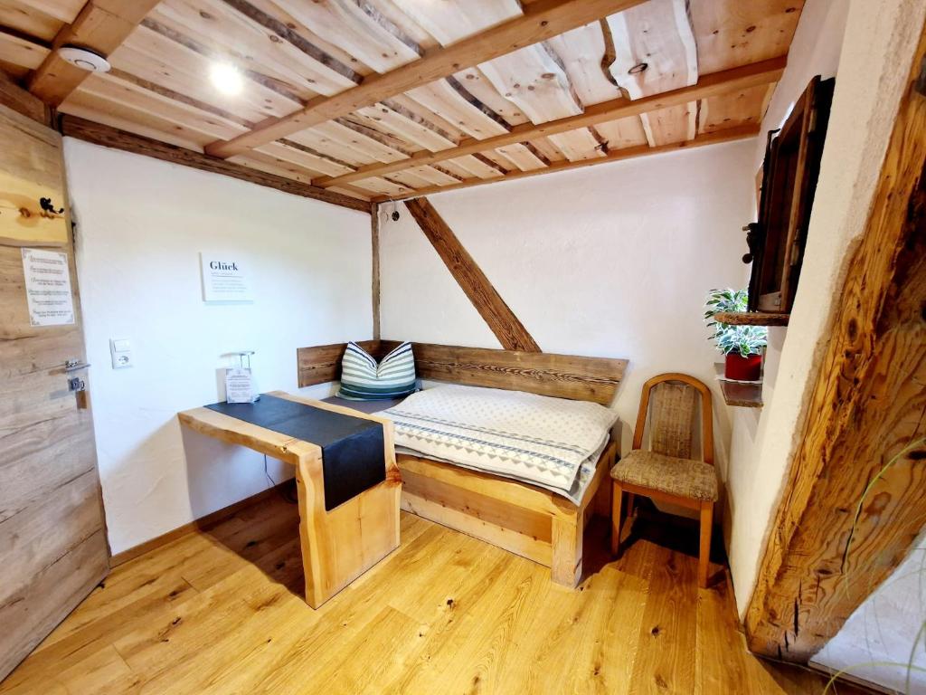 a small room with a bed and a chair at Wood & Stone Lodge 3 in Donaueschingen