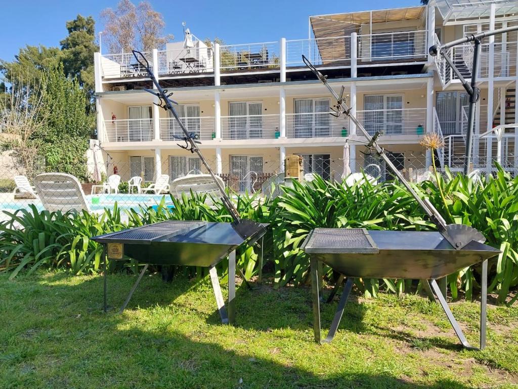 dos mesas de ping pong delante de una casa en Apart Hotel La Giraldilla en Chascomús