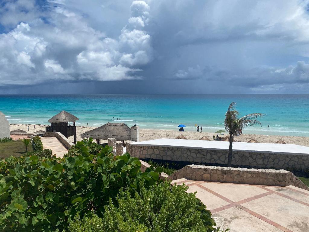 a view of a beach with a palm tree and the ocean at Solymar Condos in Cancún