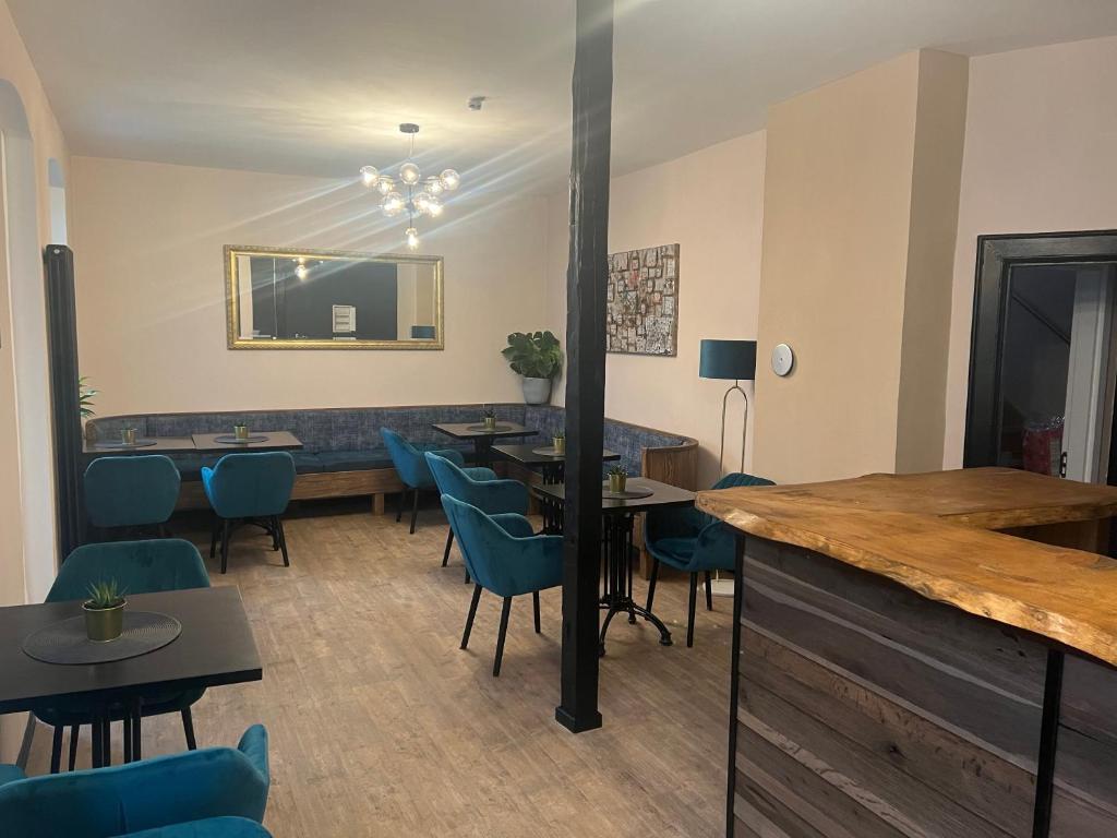 ein Restaurant mit Tischen, Stühlen und einem Spiegel in der Unterkunft Aneton Garni Hotel in Thale