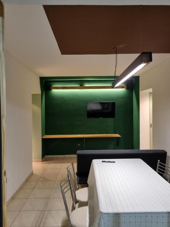 a dining room with a table and a green wall at Temporario 3B in Resistencia