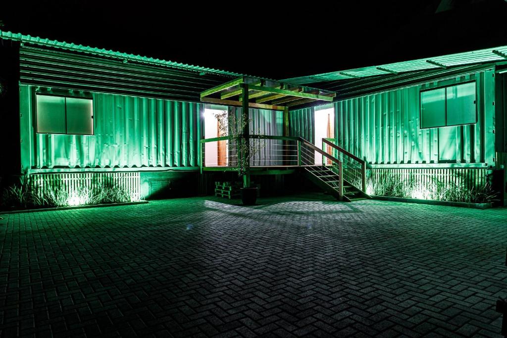 een leeg gebouw met groene lichten erop bij Suítes Container in Pomerode