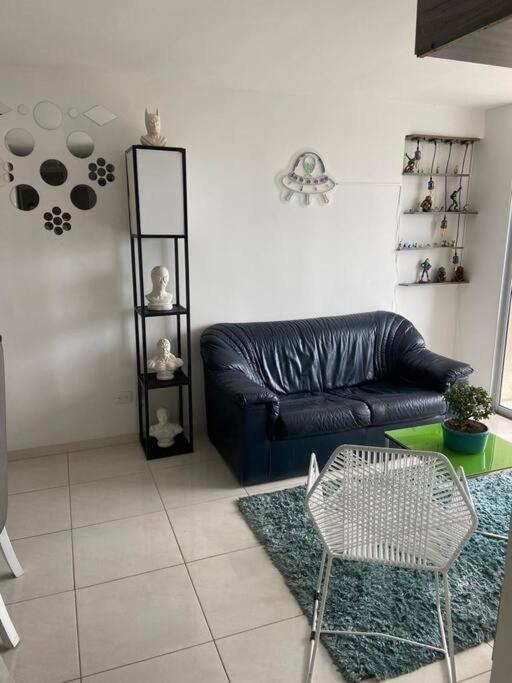 sala de estar con sofá de cuero negro y mesa en Apartamento en Bucaramanga, en Bucaramanga