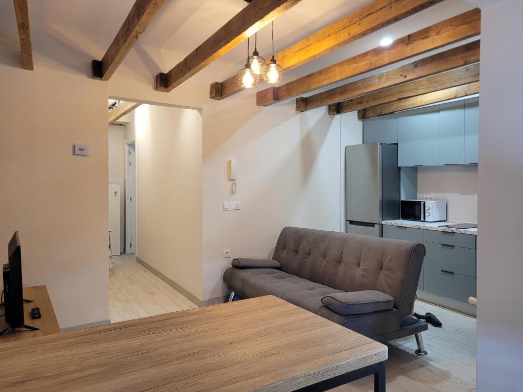 El Ático de Entrevías - Apartamento con garaje y WIFI في ليون: غرفة معيشة مع أريكة وطاولة