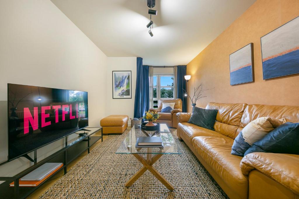 a living room with a couch and a television at Links Road Apartment ✪ Grampian Lettings Ltd in Aberdeen