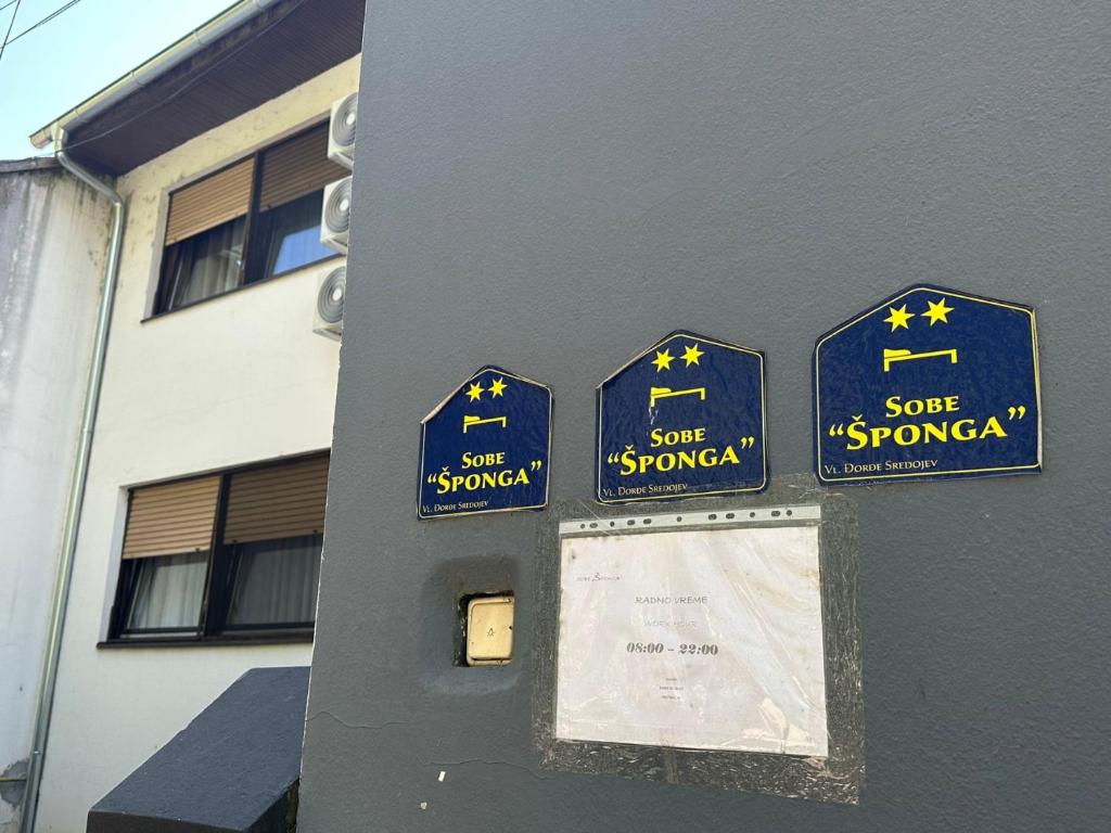 a parking meter with some signs on a building at SOBE ŠPONGA in Kikinda