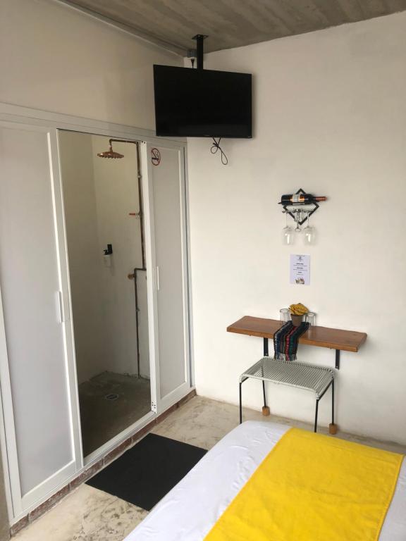 Cette chambre comprend un lit, un bureau et une fenêtre. dans l'établissement Hotel RHV, à Zihuatanejo