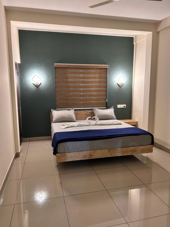 Schlafzimmer mit einem großen Bett mit einem Kopfteil aus Holz in der Unterkunft Sats residency in Sultan Bathery