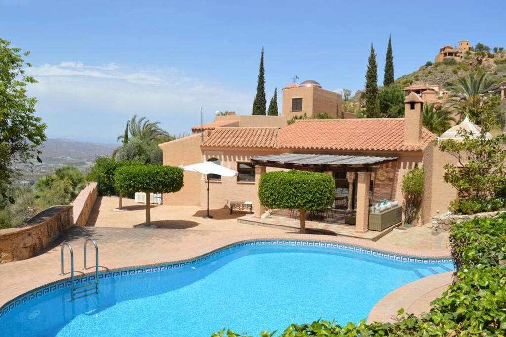 una piscina di fronte a una casa di Casa Estrella a Almería