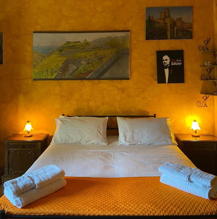 a bedroom with a large white bed with two lamps at A Casa da Nonna Brasa Holiday Home Savoca in Savoca