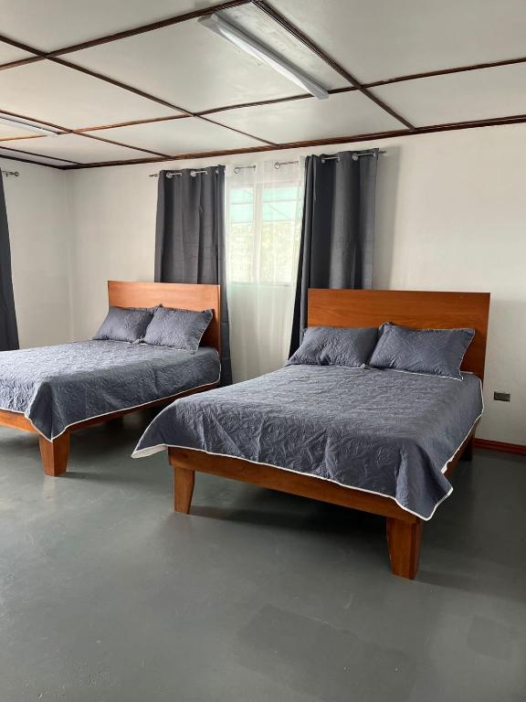 a bedroom with two beds and a window at MARIO in Alajuela City