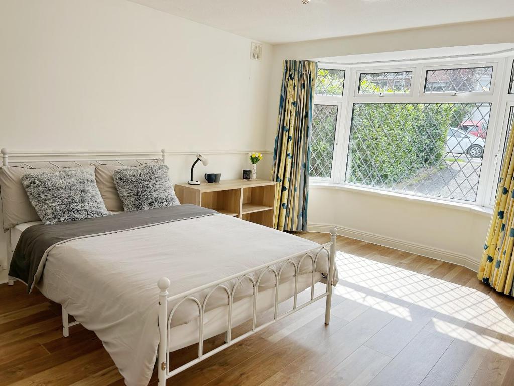 a white bedroom with a bed and a window at Marlay Grange Luxury Guest House in Dublin