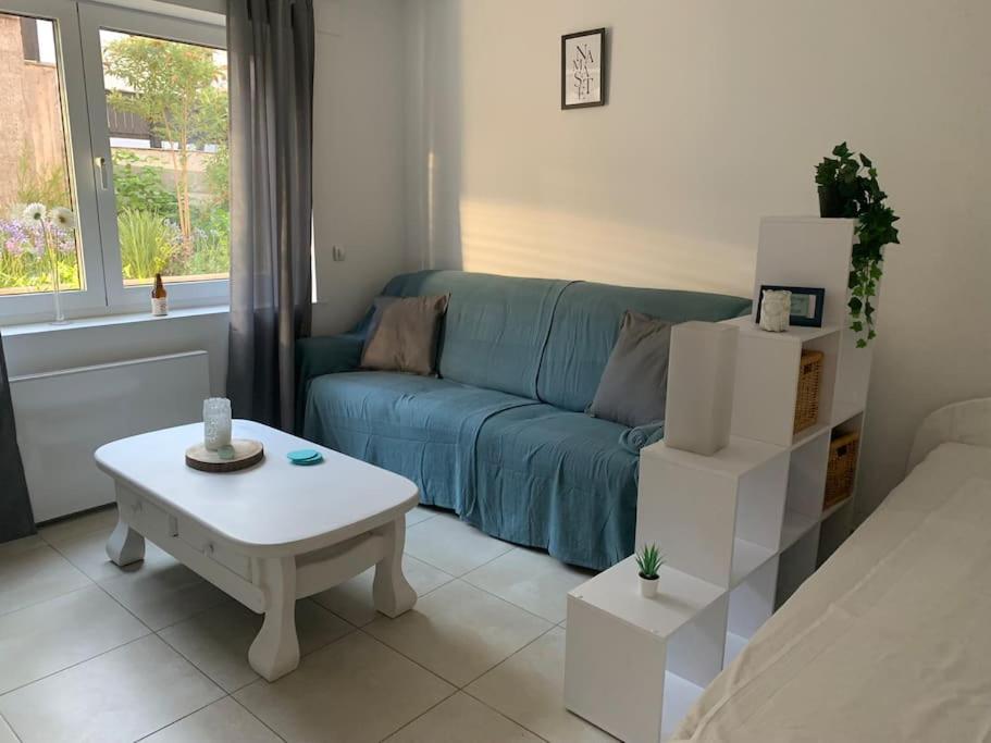 a living room with a blue couch and a coffee table at Ruhige Wohnung am Rande des Naturschutzgebietes in Ingelheim am Rhein