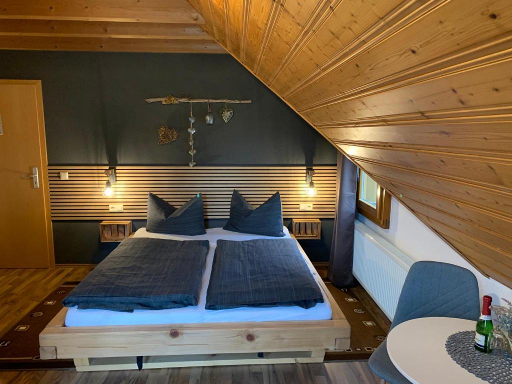 duże łóżko w pokoju z drewnianym sufitem w obiekcie Vogelbacher Hof - Dachsberg im Südschwarzwald 