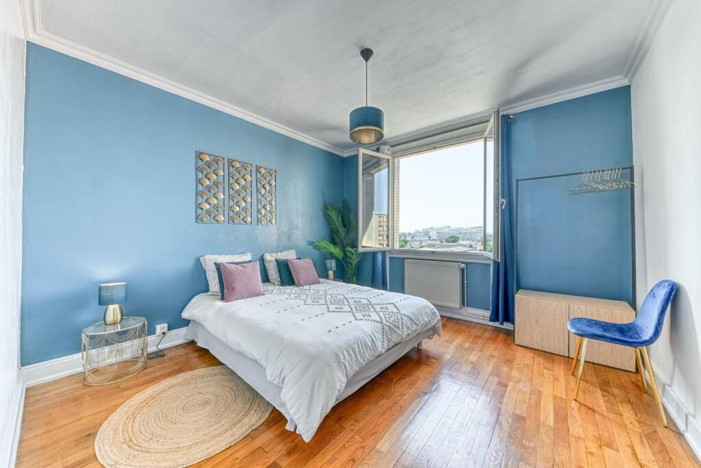 Dormitorio azul con cama y pared azul en L'élégant Zola, en Villeurbanne