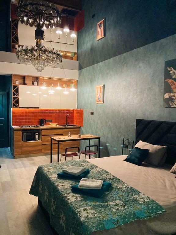 ein Schlafzimmer mit einem Bett und einem Tisch sowie eine Küche in der Unterkunft New Star in Tbilisi City