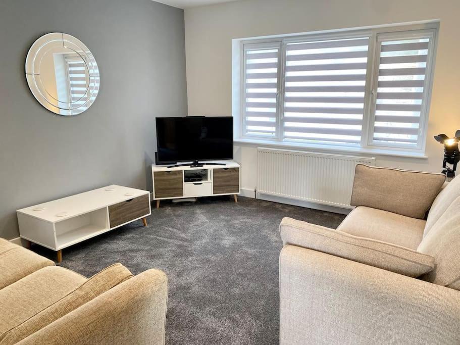 a living room with two couches and a flat screen tv at A modern, dog-friendly 3 bedrm canal side property in Bolton le Sands