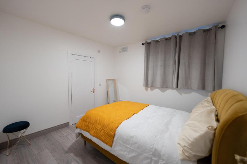 a bedroom with a bed with a yellow blanket on it at CROKE PARK STUDIO in Dublin