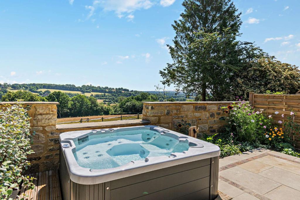 a jacuzzi tub sitting on a patio at Dairy Barn by Bloom Stays in Groombridge
