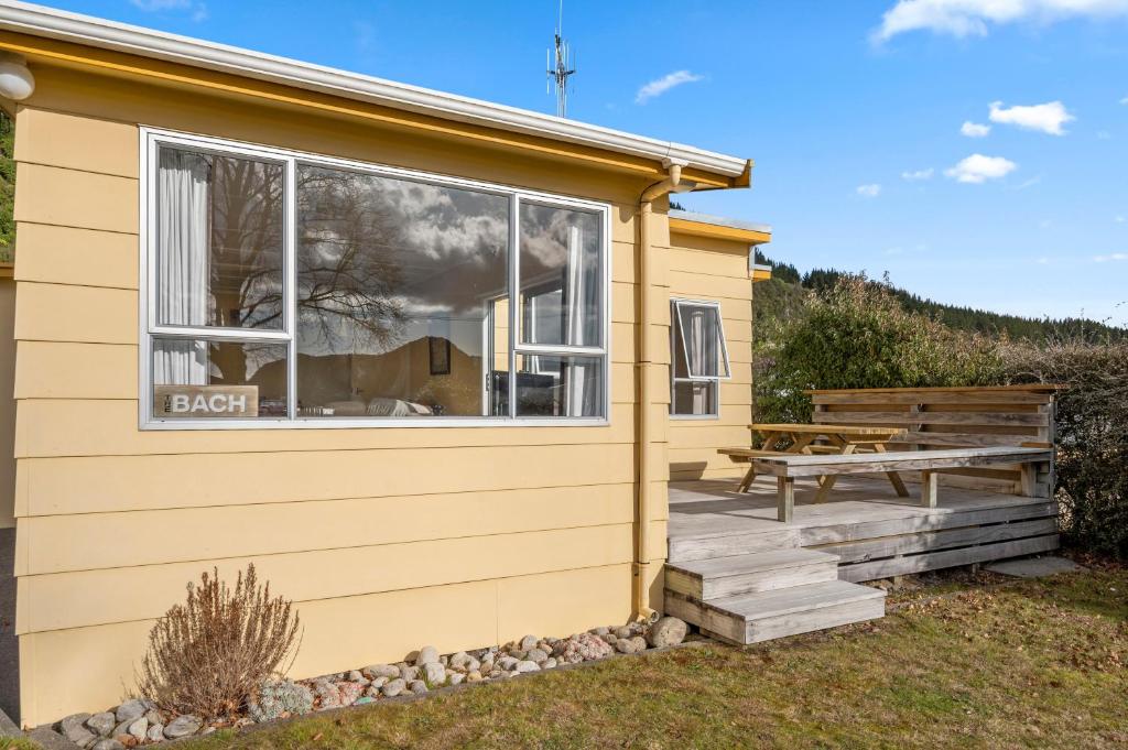 una casa pequeña con una mesa de picnic en una terraza en Lakeside Escape - Motuoapa Holiday Home, en Turangi